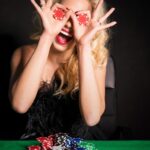 a woman holding two poker chips and smiling