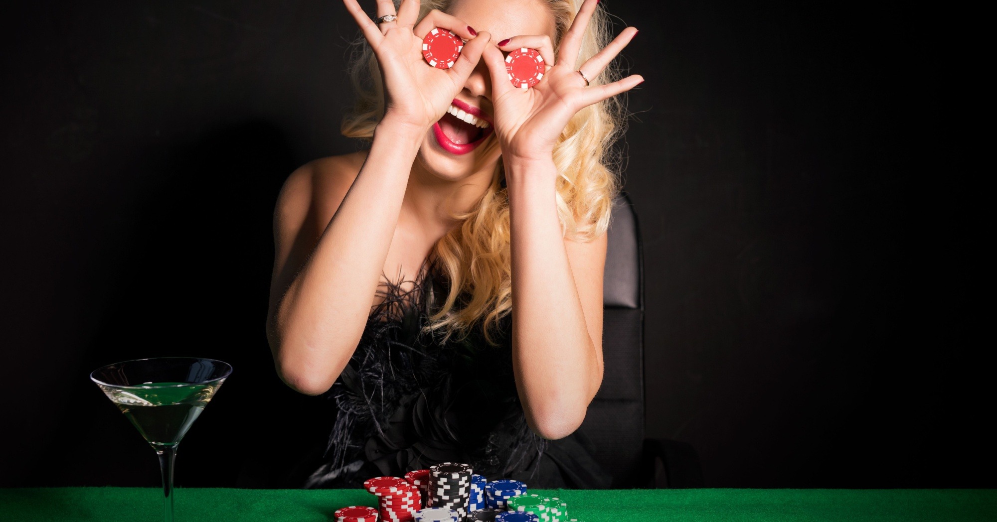 a woman holding two poker chips and smiling