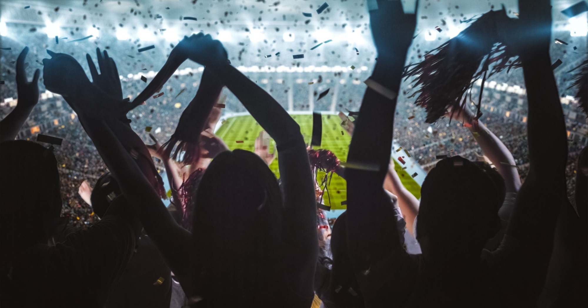 fans waving their hands in a football stadium