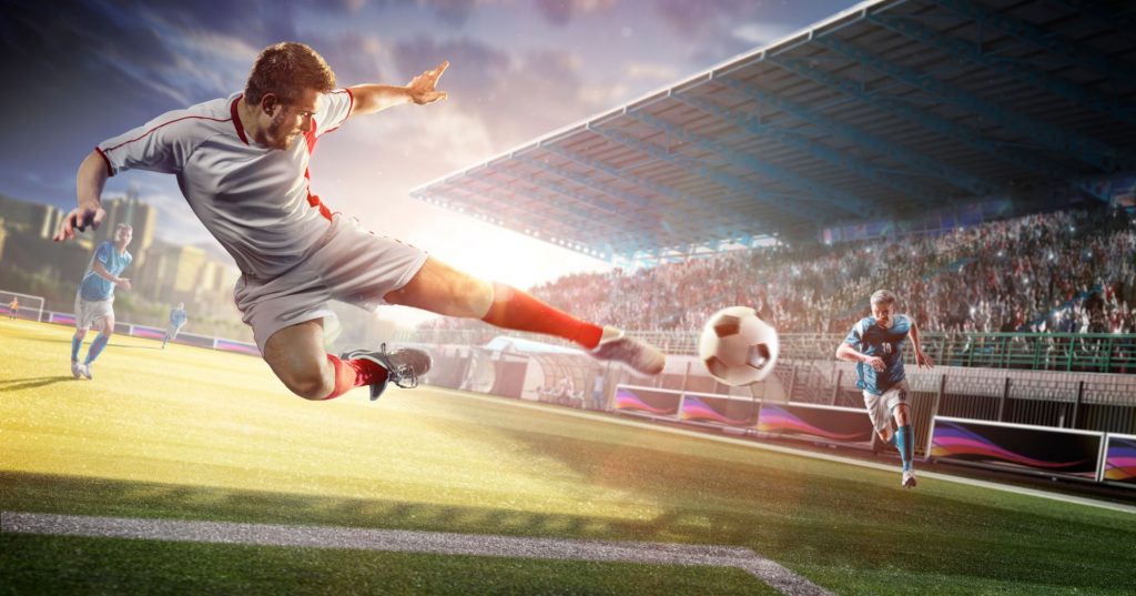 a footballer jumping and kicking a ball
