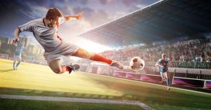 a footballer jumping and kicking a ball